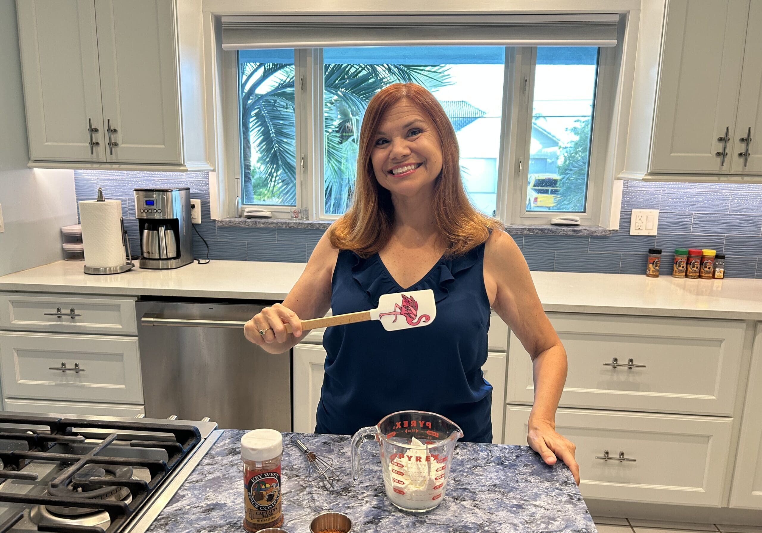 Smiling woman holding spatula in kitchen